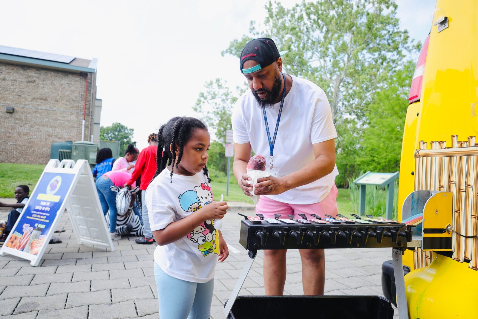 Adult and child enjoying shaved ice at a Happy Hippo event.